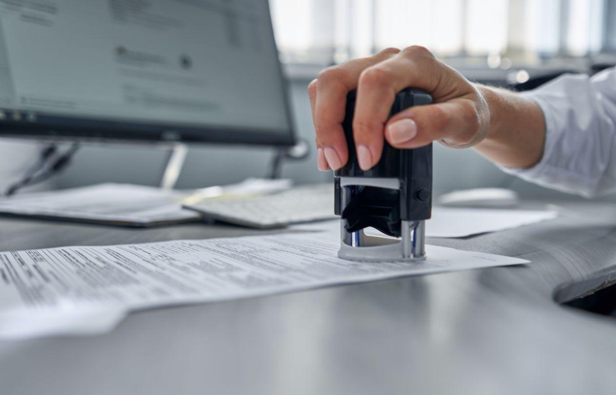 girl in the office puts a stamp on the documents